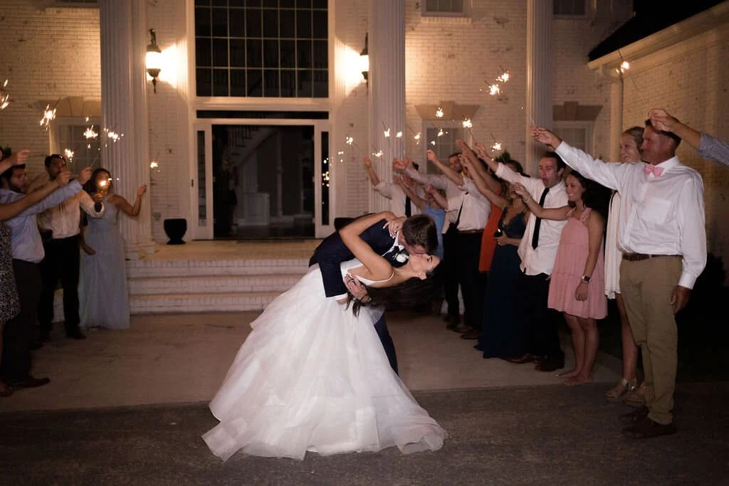Guests raise sparklers as the couple leaves the mansion